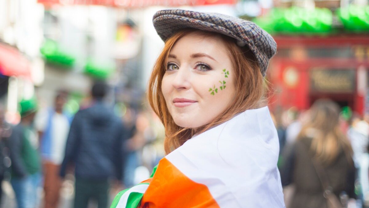 mulher-irlanda Irlandesa em close, no meio da rua, com trevo de três folhas pintado no rosto
