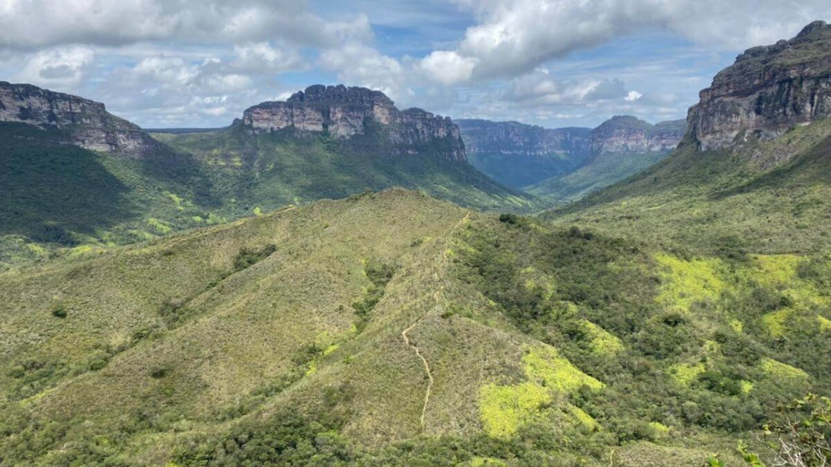 Mirante do Vale do Pati, onde dá para avistar um vale coberto de vegetação rodeado por uma cadeia de montanhas. Céu nublado.
