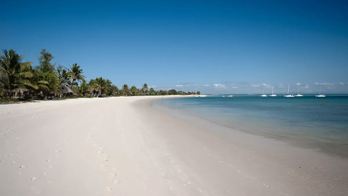 Praia de Moçambique, com areia clara e céu azul.