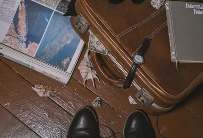 Mala, passaporte e mapa simbolizam homem se preparando para uma viagem de luxo.