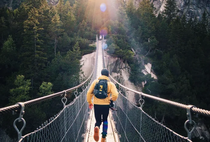 Rapaz fazendo arvorismo representa viajar sozinho
